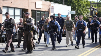 Law enforcement officers gather outside the Annunciation Church's school in response to the mass shooting. (Picture credit: AP) Minneapolis church shooting: Attacker ‘obsessed’ with killing children; admired ‘mass murderers’