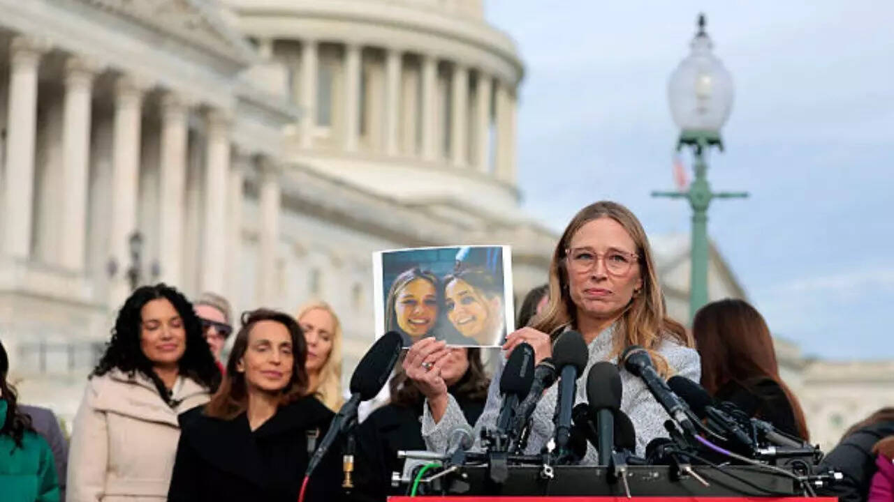 Epstein abuse survivor Annie Farmer holds up a photo of her younger self with her sister Maria Farmer