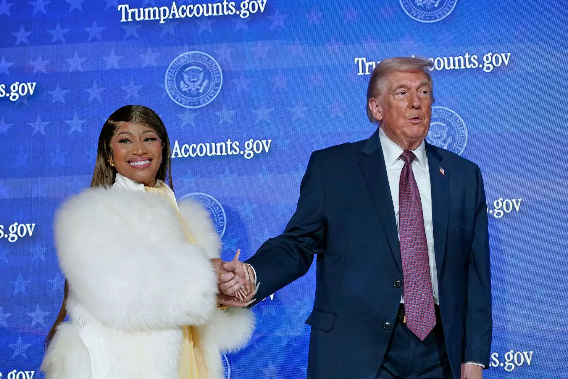 Nicki Minaj and President Donald Trump stand on stage together during an event for Donald Trump with Nicki Minaj
