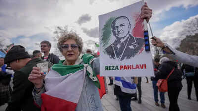 A woman holds a sign reading Tehran to impose penalties, confiscate assets of Iranians abroad who 'cooperate' with Israel, US