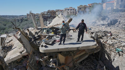 People stand on the wreckage of destroyed houses that were hit by Israeli airstrikes in Sir al-Gharbiyeh village south Lebanon. (AP photo) Human Rights Watch accuses Israel of using white phosphorus in Lebanon: Why the weapon is controversial
